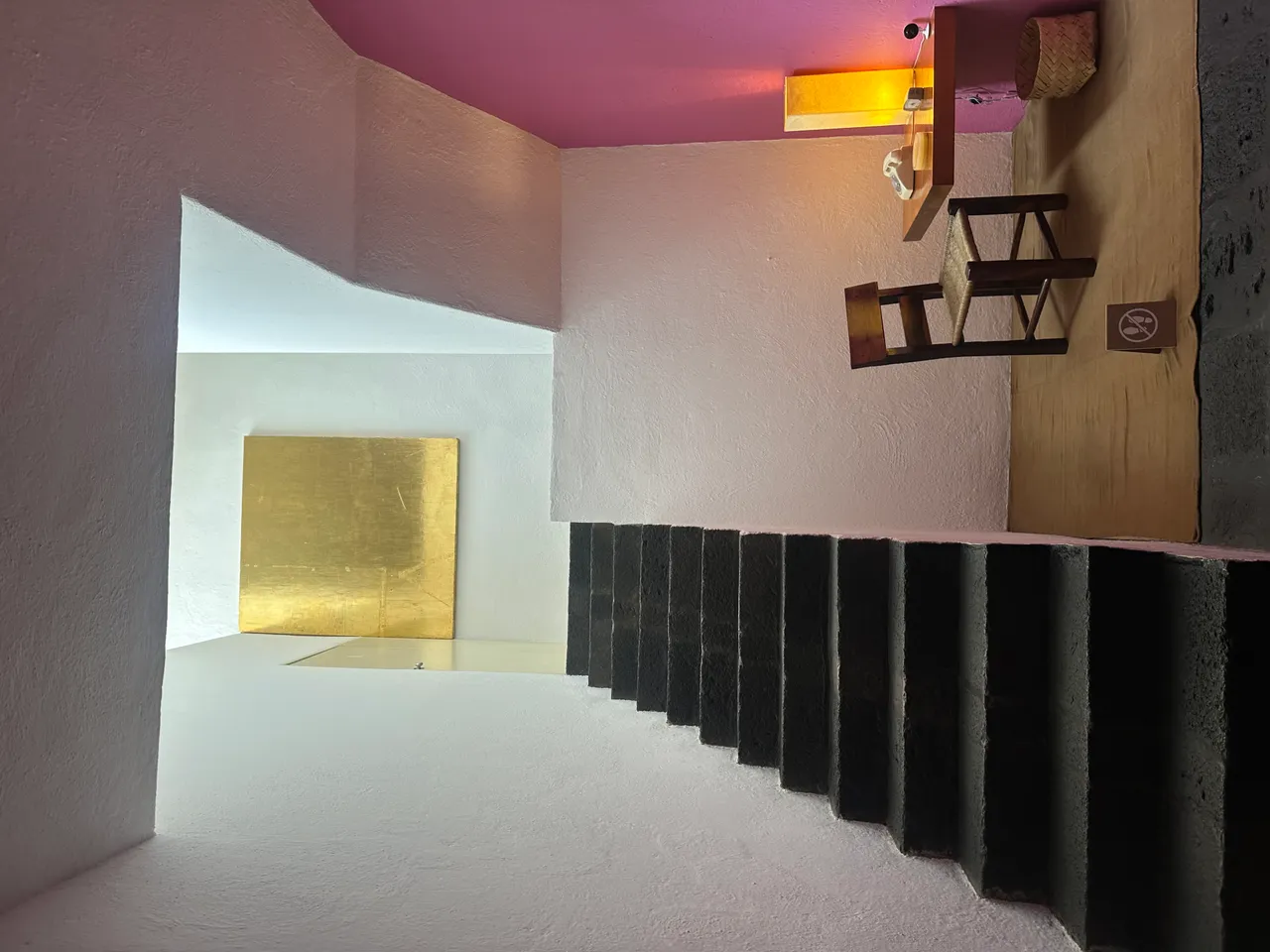 Staircase inside Casa Luis Barragan with pink ceiling and gold accent wall