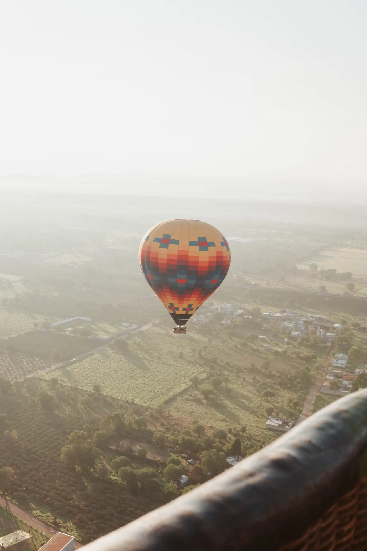 Colorful hot air balloon floating over the countryside near Teotihuacan at sunrise