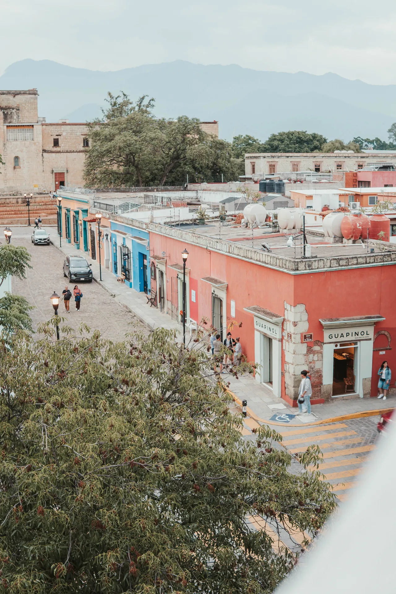 Colorful rooftop view of Oaxaca streets with mountains in the background
