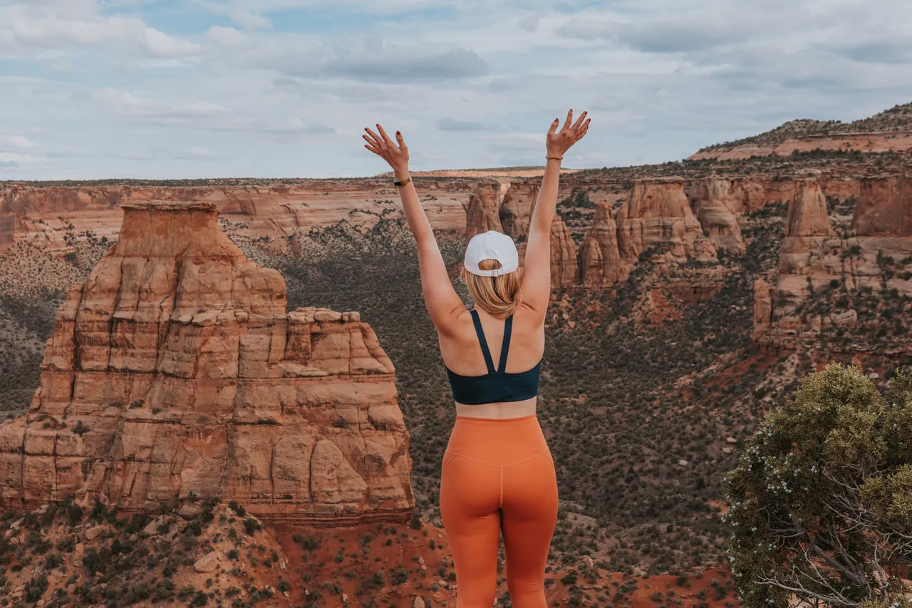 a girl with her arms up at colorado national monument