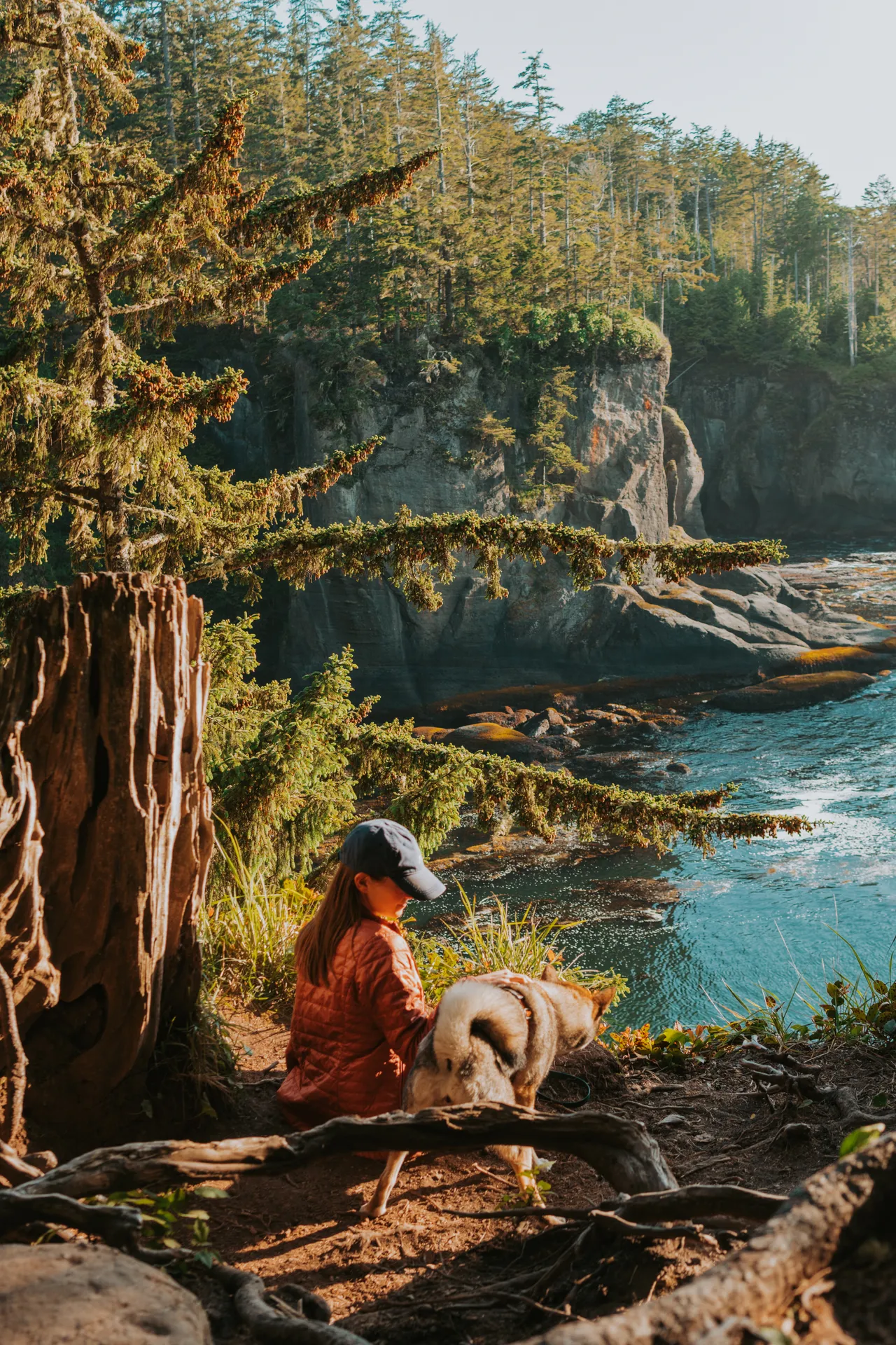 a girl and her dog at Cape Flattery at sunset