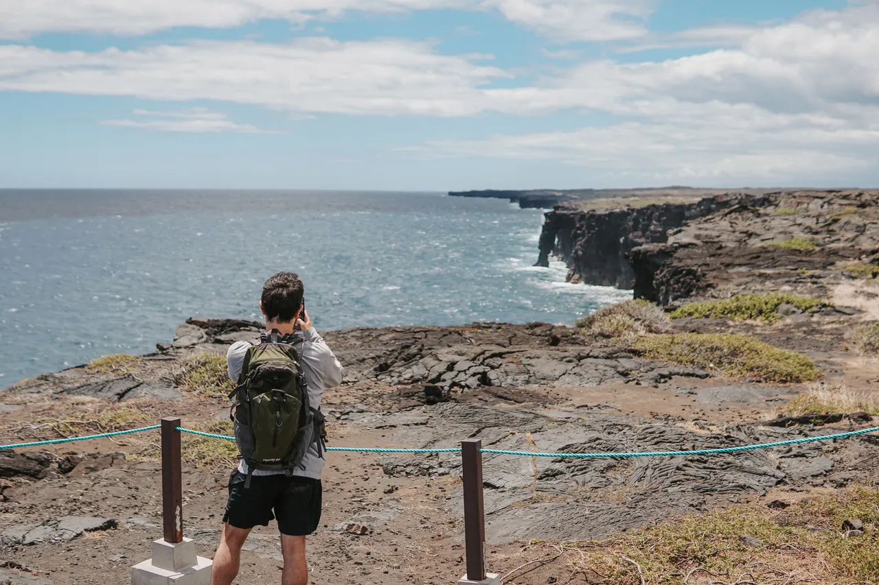 a guy taking a photo at volcano national park