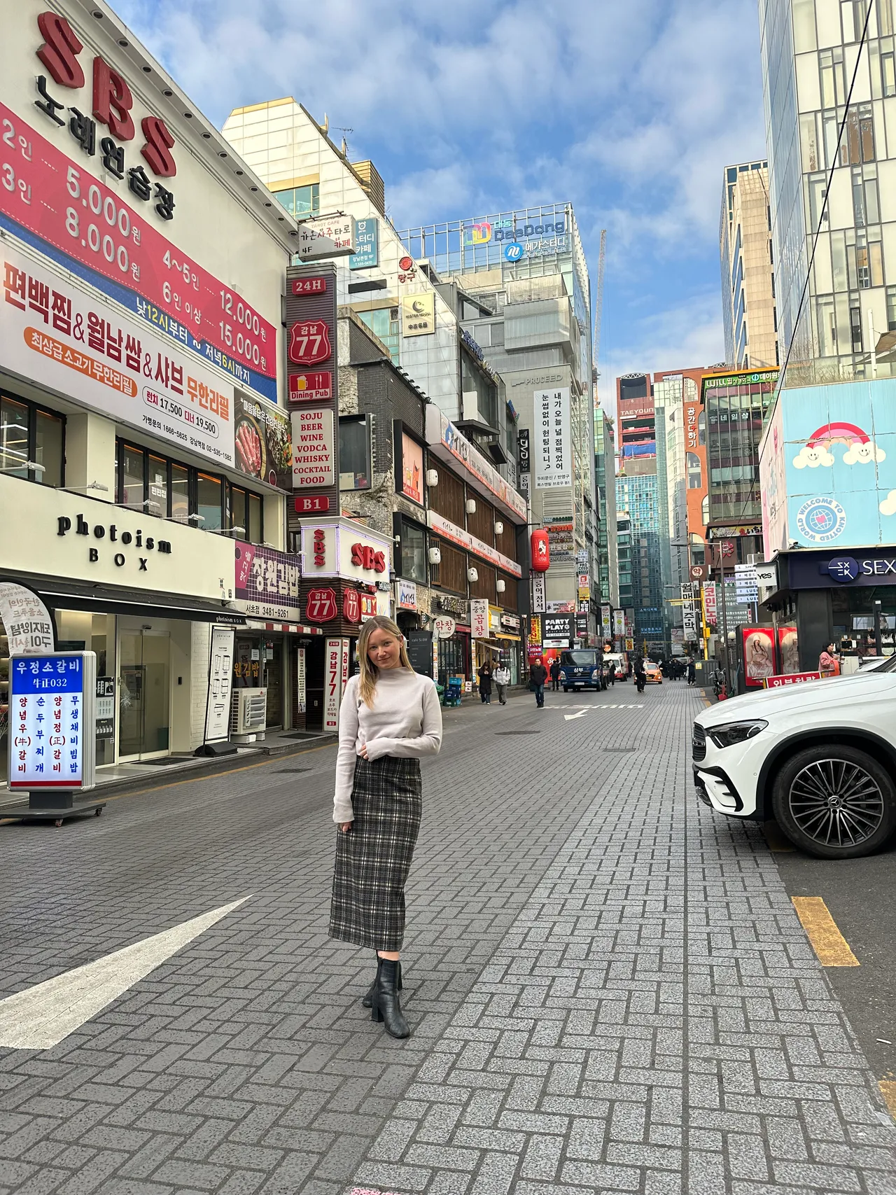 a girl standing in a long plaid skirt in seoul