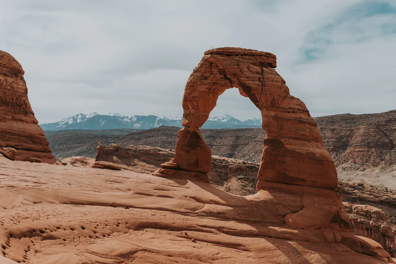 delicate arch with snow-capped la sal mountain range in the background