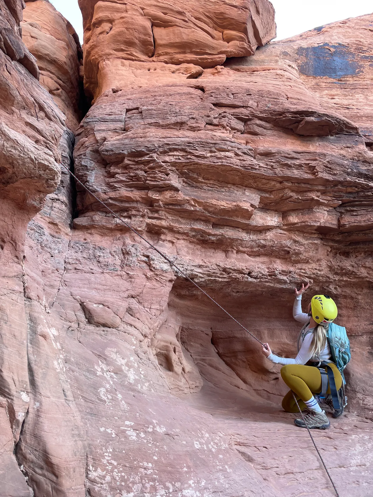 a white girl in the middle of a climb in moab utah