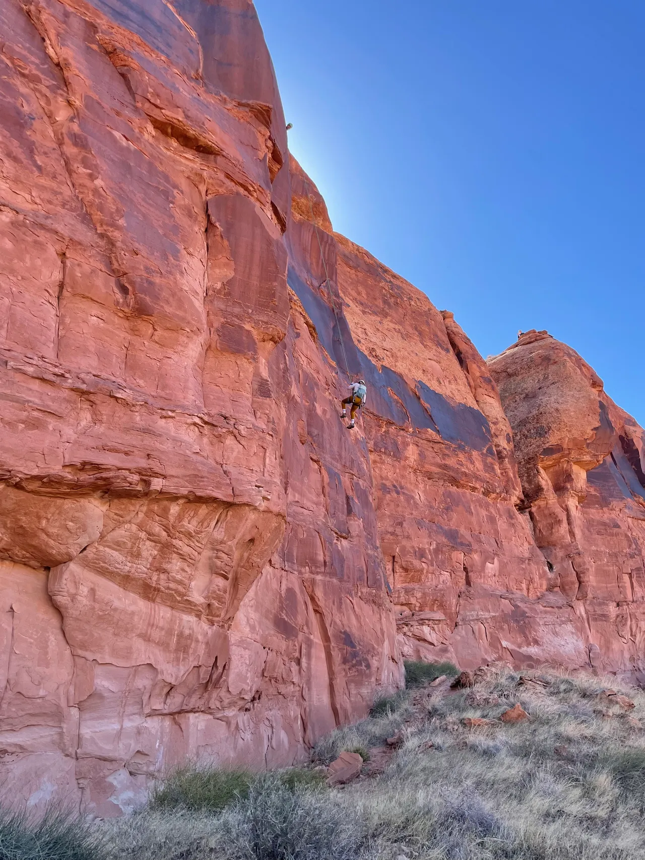 a girl rappelling down a cliff in moab utah