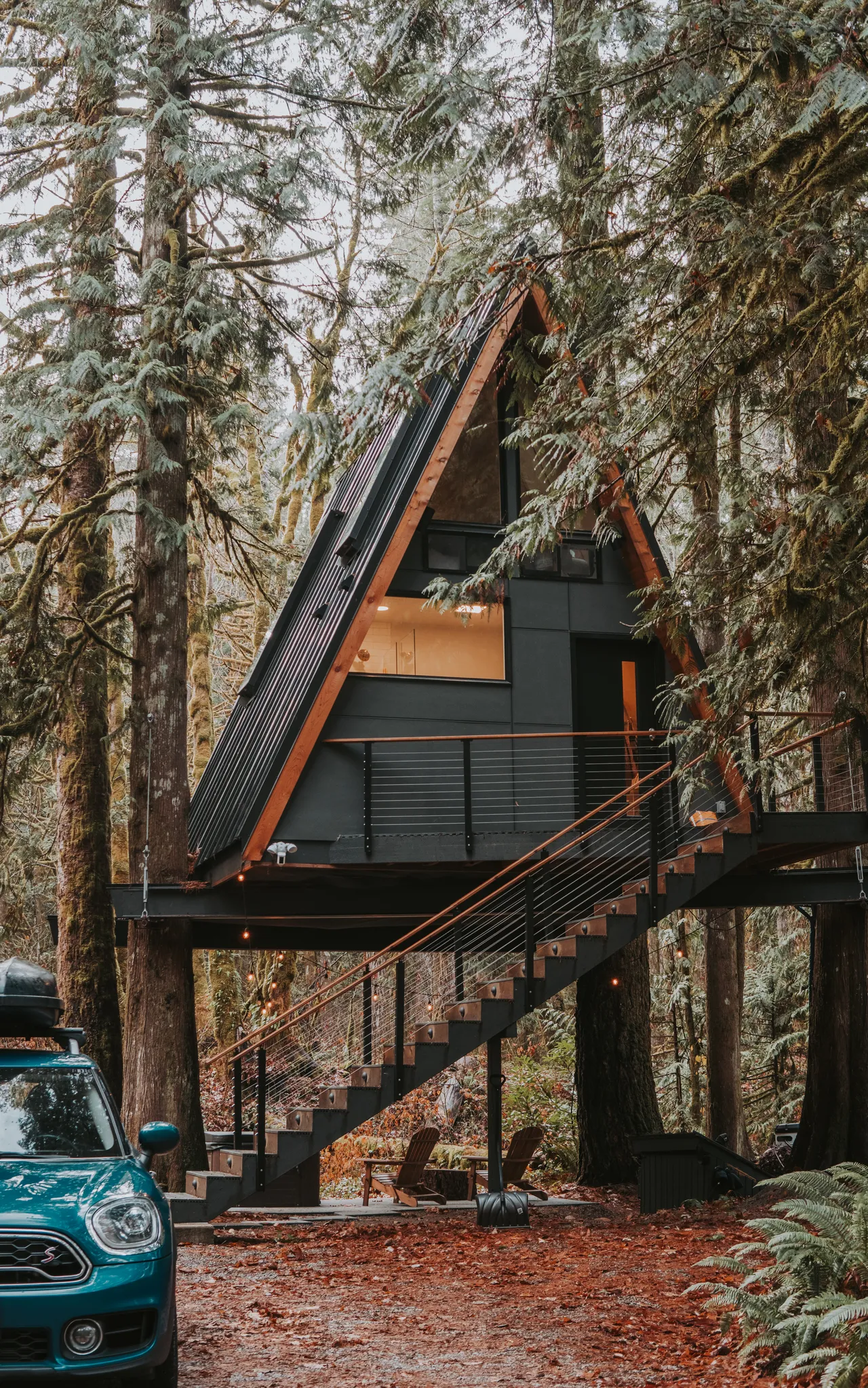 MINI Countryman parked outside an A-frame cabin in the Pacific Northwest forest