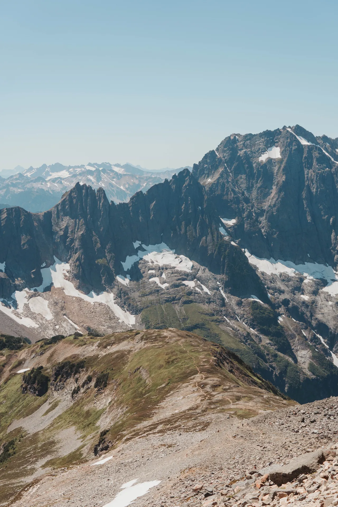 Summit ridge of Sahale Arm looking out at jagged North Cascades peaks and glaciers stretching to the horizon