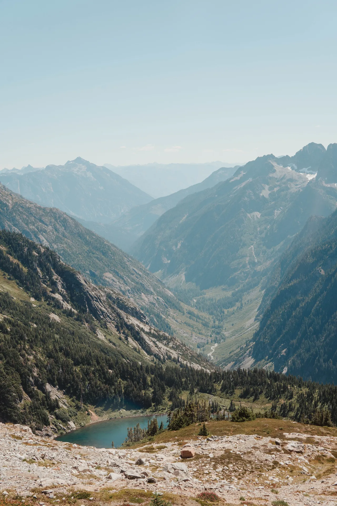 Looking down the valley from Sahale Arm with alpine lake and mountain ridges fading into haze