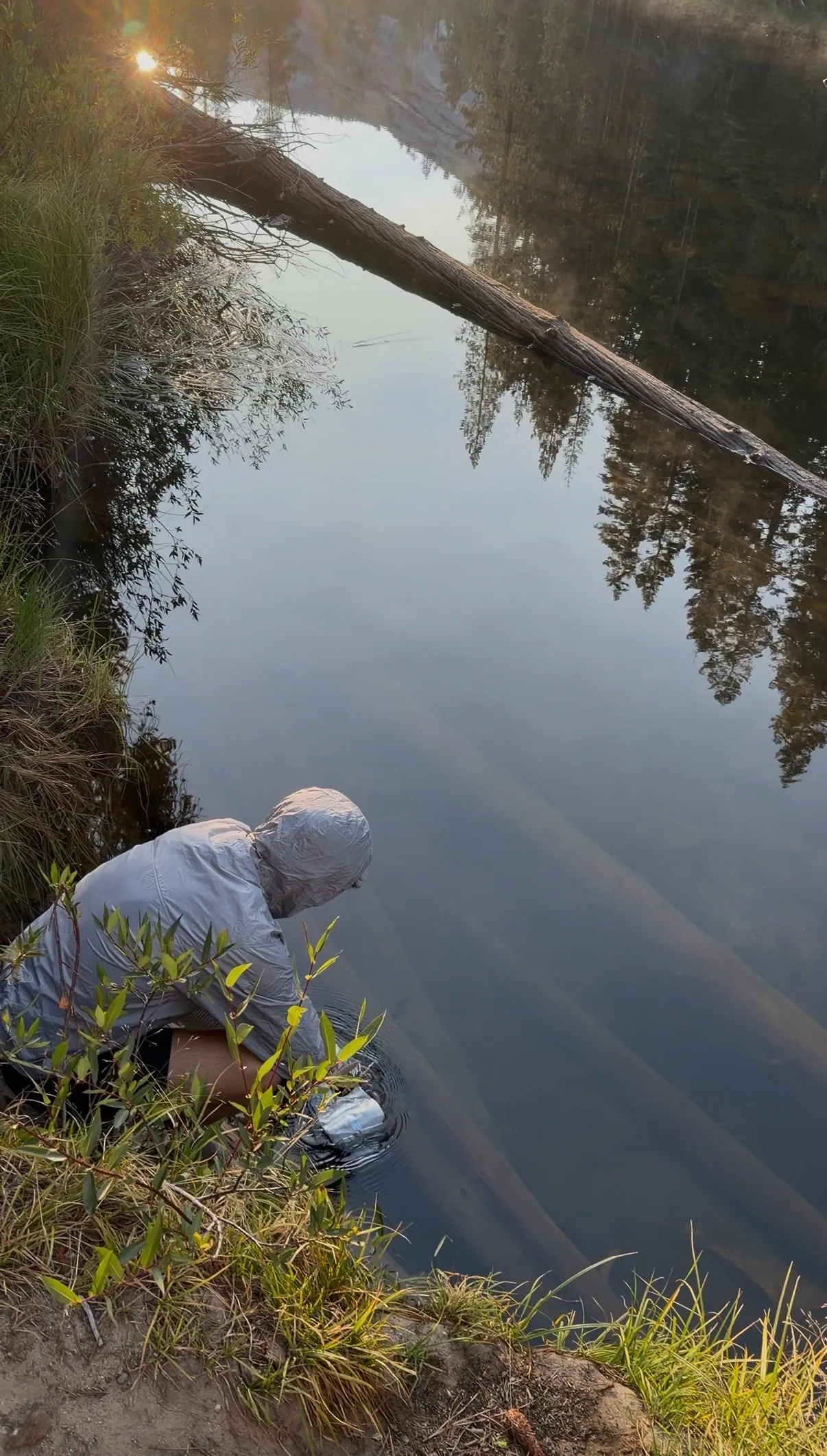 My partner crouching by the Merced River to refill water during our Half Dome hike
